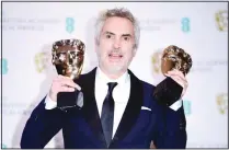  ??  ?? Alfonso Cuaron with his Best Film and Best Director awards poses fora photo. (AP)