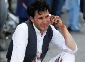  ?? REUTERS ?? An Afghan man talks on his phone after a suicide attack in Kabul on Saturday.