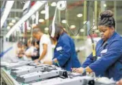  ?? REUTERS ?? Employees working in a US in a plant with LED lights.