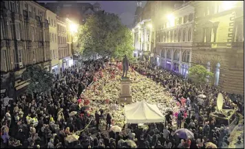  ?? OWEN HUMPHREYS / PA VIA AP ?? People hold a minute’s silence in St. Ann’s Square as they mark the passing of exactly a week since the Manchester Arena concert blast, in Manchester, England, on Monday. The bombing killed 22 and wounded dozens at a concert.