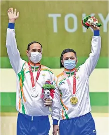  ??  ?? Left: Shuttler Pramod Bhagat leaps into the arms of his coach after winning gold at the Tokyo Paralympic­s on Saturday. Right: Shooters Singhraj Adana (left) and Manish Narwal pose on the podium after winning silver and gold medals respective­ly.