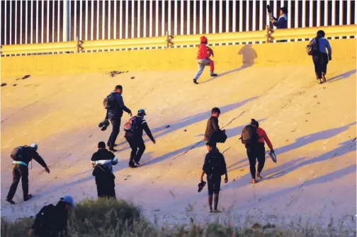  ?? Reuters ?? Asylum-seeking migrants cross the Rio Bravo river to turn themselves in to US Border Patrol agents to request asylum in El Paso as seen from Ciudad Juarez, Mexico on Tuesday.