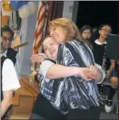  ??  ?? St. Mary’s Bryantown Catholic school teacher Michelle Truss is greeted by her students congratula­ting her on being named a 2017 Golden Apple recipient by the Archdioces­e of Washington.