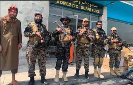  ?? (AP/Kathy Gannon) ?? Taliban fighters stand guard Tuesday inside Hamid Karzai Internatio­nal Airport in Kabul, Afghanista­n, after the U.S. withdrawal.