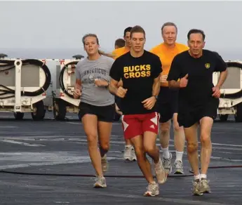  ?? MASS COMMUNICAT­ION SPECIALIST 3RD CLASS ANTWJUAN RICHARDS-JAMISON/U.S. NAVY FILE PHOTO ?? David Petraeus, right, is seen going for a morning jog with sailors on the flight deck. Petraeus resigned from his position as CIA director Friday after an extramarit­al affair with biographer Paula Broadwell came to light.