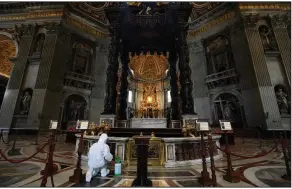  ?? (AP/Andrew Medichini) ?? A worker sanitizes the baroque sculpted bronze canopy of St. Peter’s Baldachin inside St. Peter’s Basilica on Friday at the Vatican.