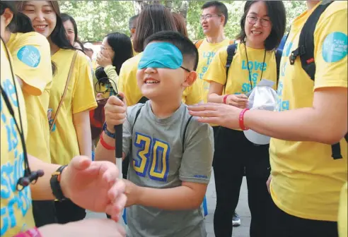  ?? PHOTOS PROVIDED TO CHINA DAILY ?? A boy at the Wishbone Day event walk with his eyes covered to experience OI which may affect eyesight in some cases.