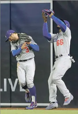  ?? Gregory Bull Associated Press ?? DODGERS right fielder Yasiel Puig, right, makes a catch at the wall for the out denying Padres’ Jose Pirela, as Chris Taylor nearly collides with him.