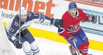  ?? POSTMEDIA NEWS ?? Canadiens’ Alexander Romanov and Jets’ Adam Lowry skate behind the Montreal net during Game 4.