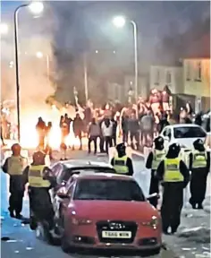  ?? ?? Rioters in balaclavas in Ely, Cardiff, hurled objects such as paving stones at the police