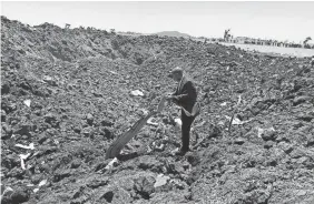  ?? FACEBOOK VIA AP ?? Tewolde GebreMaria­m, CEO of Ethiopian Airlines, examines wreckage of the Boeing 737-8 MAX after it crashed outside Addis Ababa.