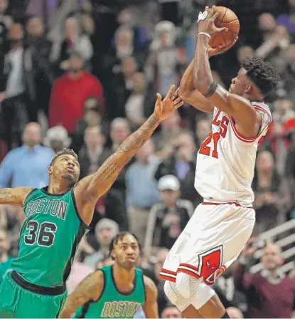  ??  ?? The Bulls’ Jimmy Butler is fouled by the Celtics’ Marcus Smart in the final second Thursday at the United Center. | GETTY IMAGES
