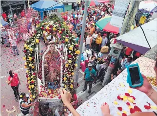  ?? AMELIA ANDRADE / EXPRESO ?? Procesión. Desde los balcones, los devotos lanzan pétalos de rosas y confeti a la imagen de san Jacinto.