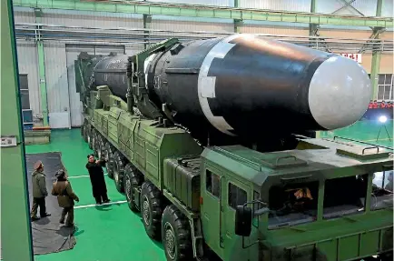  ?? PHOTO: KOREA CENTRAL NEWS AGENCY ?? North Korean leader Kim Jong Un, third from left, and what the North Korean government calls the Hwasong-15 interconti­nental ballistic missile.