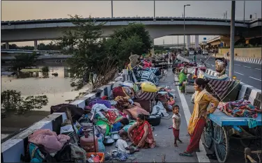  ?? ?? Belongings of dozens of families lay piled on a roadside Sept. 28 after they evacuated the flooded banks of the Yamuna River.