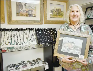  ?? (NWA Democrat-Gazette/Rachel Dickerson) ?? Marcy Effinger, a member of the Artisan Alliance at Wishing Spring, is pictured at the Wishing Spring Gallery with some of her paintings and magnetic jewelry. She is a former art teacher and taught private watercolor classes for more than 40 years.