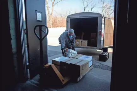  ?? KELSEY KREMER/USA TODAY NETWORK ?? Terry Evans unloads boxes of equipment that was meant for the now-canceled Iowa Mission of Mercy two-day community dental clinic. It will be donated to the Polk County Health Department in Des Moines, Iowa.