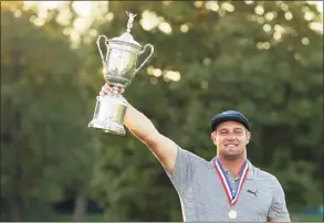  ?? Gregory Shamus / Getty Images ?? Bryson DeChambeau celebrates with the championsh­ip trophy after winning the U.S. Open on Sunday at Winged Foot Golf Club in Mamaroneck, N.Y.