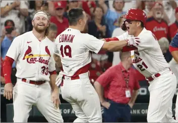  ?? AP photo ?? The Cardinals’ Tommy Edman (center) is congratula­ted by teammates Brendan Donovan (left) and Lars Nootbaar after hitting a game-winning, two-run double Wednesday.