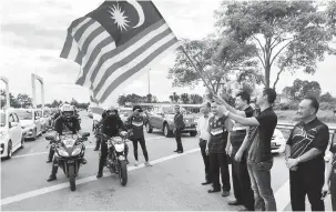  ??  ?? SELAMAT BERKONVOI: Fazzrudin dan Dr Azmi melakukan ‘flag off’ peserta konvoi di Jambatan Tun Salahuddin di Kuching, semalam.
