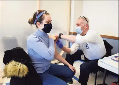  ?? Tyler Sizemore / Hearst Connecticu­t Media ?? Caroline Beit, an EMT, receives the second dose of her COVID-19 vaccine from Jim Anderson at the town of Greenwich COVID-19 vaccinatio­n clinic at Town Hall in January.