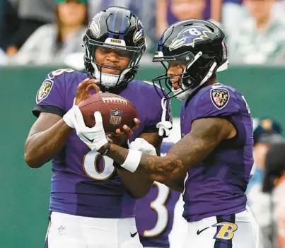  ?? RICH SCHULTZ/AP ?? Ravens wide receiver Rashod Bateman, right, gives the ball he caught for a touchdown to quarterbac­k Lamar Jackson, who pretends to autograph it, during the season opener against the Jets on Sept. 11 in East Rutherford, New Jersey.