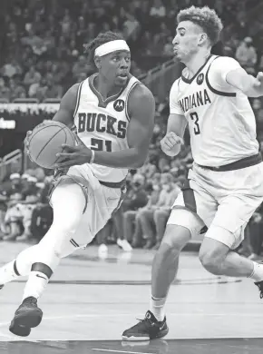  ?? MARK HOFFMAN/MILWAUKEE JOURNAL SENTINEL ?? Bucks guard Jrue Holiday drives past Pacers guard Chris Duarte during the first half Wednesday.