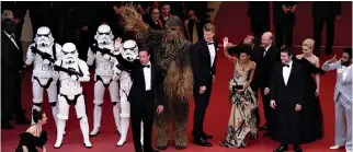  ??  ?? CANNES PREMIERE: (L-R) Stormtroop­ers, producer Simon Emanuel, Chewbacca, actors Joonas Suotamo and Thandie Newton, director Ron Howard, actors Alden Ehrenreich, Emilia Clarke, and Donald Glover wave as they arrive on May 15 for the screening of the...