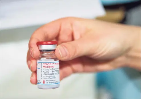  ?? Jacob King / Pool / AFP / TNS ?? A health care profession­al holds a vial of the Moderna COVID-19 vaccine in April.