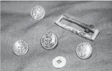  ?? DOUGLAS STENTON THE CANADIAN PRESS VIA GOVERNMENT OF NUNAVUT ?? A mother-of-pearl button, gilt brass buttons and a gilt buckle frame from a naval officer's uniform were found at a Franklin expedition gravesite.