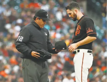  ?? Santiago Mejia / The Chronicle ?? Umpire Alfonso Marquez checks the hat, glove and belt of Giants pitcher Alex Wood in the first inning Saturday.