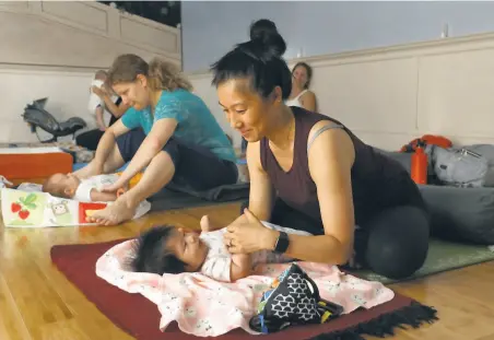  ?? Photos by Liz Hafalia / The Chronicle 2019 ?? Amanda Chau takes a class for moms and babies with her daughter Emma in 2019 at Yoga Tree Valencia in San Francisco. The chain’s studios have been closed since midMarch due to the pandemic and will not reopen for the foreseeabl­e future.