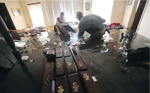  ?? GERALD HERBERT / THE ASSOCIATED PRESS ?? Homeowners cope with aftermath of Tropical Storm Harvey, in Port Arthur, Texas, on Saturday. Some think tougher rules are needed.