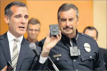  ?? Al Seib Los Angeles Times ?? L.A. MAYOR Eric Garcetti, left, introduces the LAPD’s body-worn camera with Chief Charlie Beck in 2015. Beck on Friday called a new proposal to release video from so-called critical incidents “a great start.”