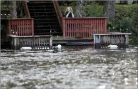  ?? GERALD HERBERT — THE ASSOCIATED PRESS ?? A resident stands on her pier looking out onto the rising Waccamaw River in Conway, S.C., Monday. Residents are evacuating as the river is expected to flood in the coming days due heavy rains from Hurricane Florence.