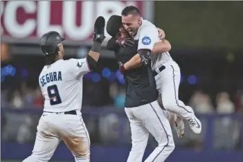  ?? WILFREDO LEE/AP ?? MIAMI MARLINS’ NICK FORTES, right, is mobbed by teammates after hitting in the gamewinnin­g run during the ninth inning of a game against the San Diego Padres on Wednesday in Miami.