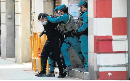  ?? ALEJANDRO GARCÍA / EFE ?? Agentes de la Guardia Civil custodian, tras registrar su domicilio en Barcelona, al marroquí detenido por su vínculo con el Daesh.