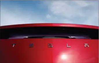  ?? DAVID ZALUBOWSKI — THE ASSOCIATED PRESS FILE ?? In this file photo, the sun shines off the rear deck of a roadster on a Tesla dealer’s lot in the south Denver suburb of Littleton, Colo. Tesla stock is sinking Monday, July 23, after the Wall Street Journal reported that the company asked suppliers for refunds to help it turn a profit.