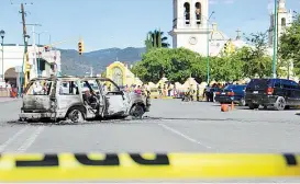  ??  ?? El auto en el que viajaban las víctimas en el municipio de Acatlán de Osorio.