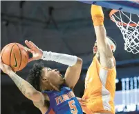  ?? ALAN YOUNGBLOOD/AP ?? Florida guard Will Richard drives to the basket against Tennessee forward Olivier Nkamhoua during Wednesday night’s game in Gainesvill­e, Florida.