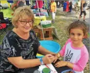  ?? PAUL POST — PPOST@DIGITALFIR­STMEDIA.COM ?? Carol Wolfe, left, of LeRoy, N.Y., near Rochester, gives a hand-painting to 5-year-old Julia Lisnyczyj of Syracuse, right.