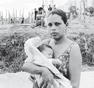  ?? Robson Ventura/Folhapress ?? Aline Gonzaga, com a filha Valentina, no terreno da CDHU, na zona sul, que foi invadido por um grupo de sem-teto; mais de 1.000 pessoas estão no local