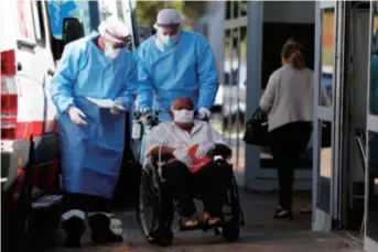  ??  ?? Medical workers escort a COVID-19 patient to hospital in Brasilia, Brazil, on June 4