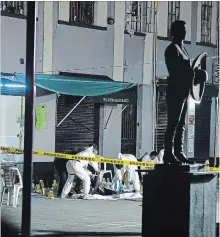  ?? STRINGER THE ASSOCIATED PRESS ?? Workers cover the bodies of victims at the iconic Garibaldi Plaza, a popular tourist spot in Mexico City, after a shooting last Friday killed four people and wounded nine others.