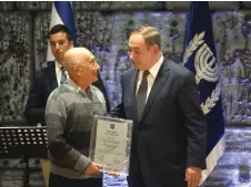  ?? (Marc Israel Sellem/The Jerusalem Post) ?? PRIME MINISTER Benjamin Netanyahu awards Moshe Sharett’s son Ya’acov with an honorary mention at the President’s Residence yesterday.