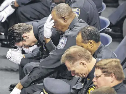  ?? CURTIS COMPTON PHOTOS / CCOMPTON@AJC.COM ?? A row of university police, campus security and Americus police officers bow in prayer during the funeral service of Georgia Southweste­rn State University campus police officer Jody Smith at the university on Wednesday in Americus.