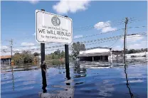  ?? GERALD HERBERT/ASSOCIATED PRESS ?? A sign commemorat­ing the rebuilding of the town of Nichols, S.C., which was flooded two years earlier from Hurricane Matthew, stands in floodwater­s Friday in the aftermath of Hurricane Florence. Virtually the entire town is once again flooded.