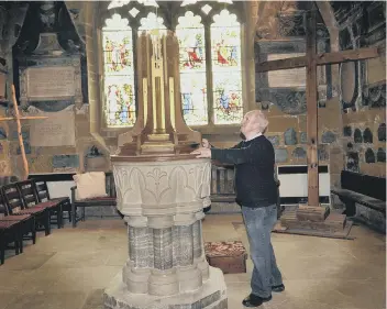  ??  ?? Verger Terry Kinsella inside the church with an Easter cross in the background. 180940h