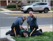  ?? IMAGE FROM SCREENSHOT ?? Two unidentifi­ed Collegevil­le Police Officers handcuff an Ursinus College student at an April 9protest.