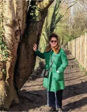  ??  ?? ●●Jo Ward, chair of Heatons Conservati­on Group, at the Hawthorn road entrance to Heaton Mersey Common. The tree would be cut down under the cycle path proposals.